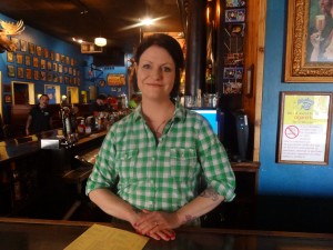 Bar manager Becca Schock stands behind the bar waiting to serve customers.She also greats her guests and bids them good-bye.