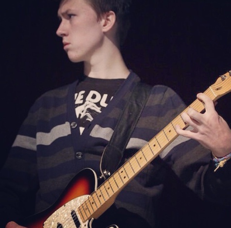 Hayden Jensen plays lead guitar, while the rest of the band performs.