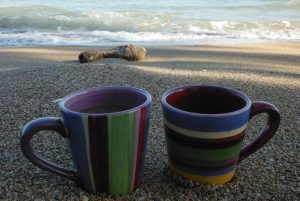 Two coffee mugs rest in the sand on a beach in the northern part of Puerto Rico. Tropical destinations such as Puerto Rico are popular with not only FHN students, but others around the world.