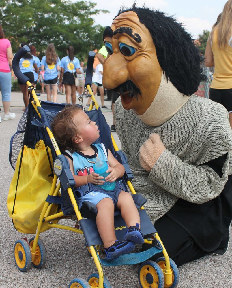 Norm greets a child at Black and Gold Day right before he started crying. Many children and students got their pictures taken with Norm. Norm also took photos in the photo booth publications was holding.