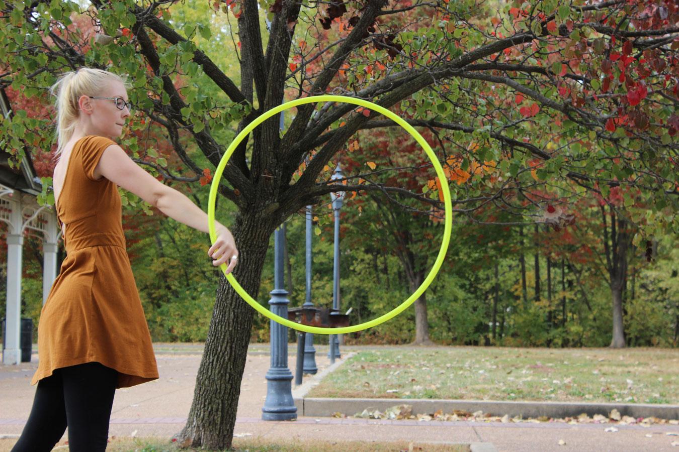Lizzie Fletcher does the iso pop trick with one of her polypro hula hoops on Oct. 24 at Main Street St.Charles. There are many tricks in hoop dancing including some easier ones: isolation, vortex, etc.