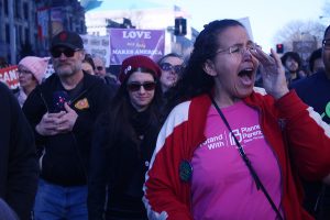A woman yells along with the crowd during the march. Many women held signs and spoke about why they felt this march was needed.