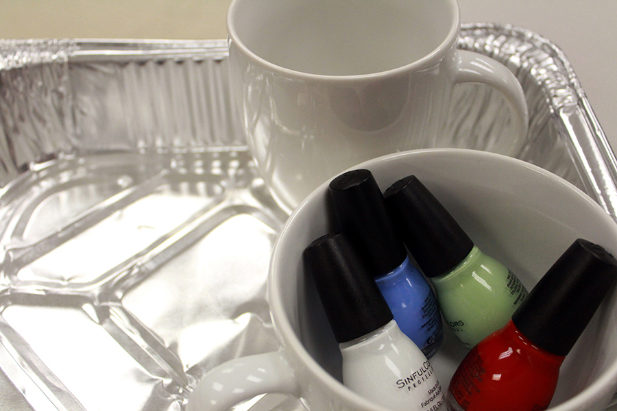 First collect your supplies: 2 bottles of nail polish, a blank mug and a disposable roasting pan.