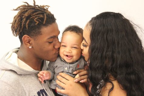 Donnell Hawkins (left) and India Deshay (right) kiss their child, Donnell DeVanté Hawkins Jr. (Alex Rowe)