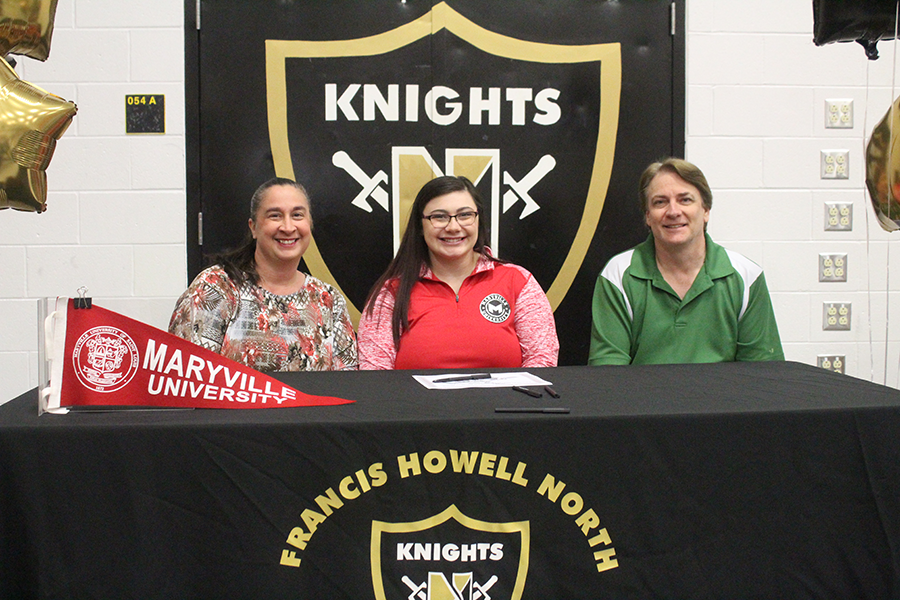 Senior Courtney Lauer, with her parents, signs with Maryville University.