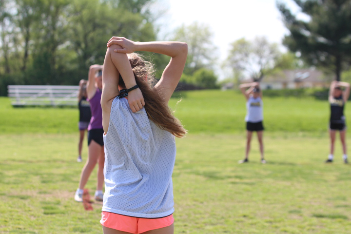 Jenna Gehricke stretches with her team before they begin their practice. Gehricke is one of the many girls joining lacrosse for the first time. This is only the second year for girls lacrosse at FHN.

