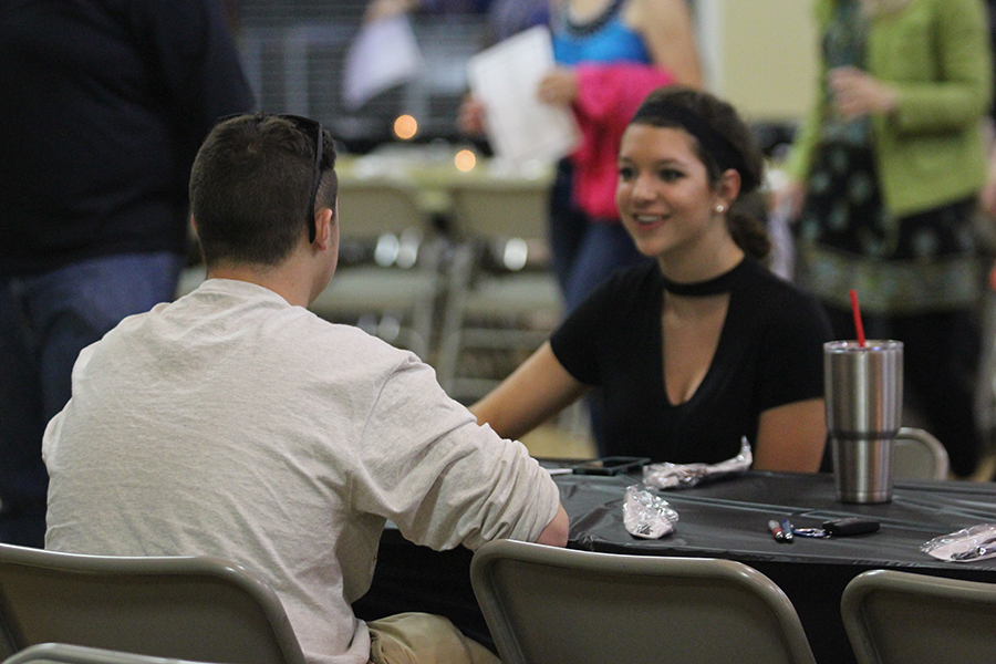 Junior Devyn Meyer talks at a table during the Jazz Band dinner concert.