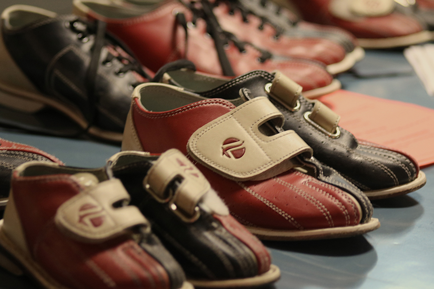 The Bowling shoes are lined up ready for people to grab and put on.