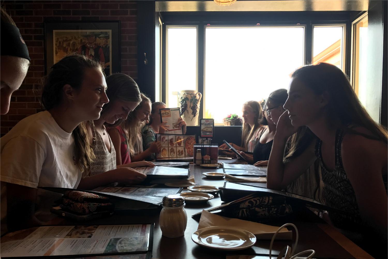 The girls’ cross country team sits at Pasta House waiting for their server during a team dinner the night before their first meet. The meet took place Aug. 25, at McNair Park. 