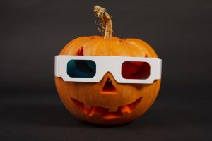 Orange halloween pumpkin in 3d glasses on black background.