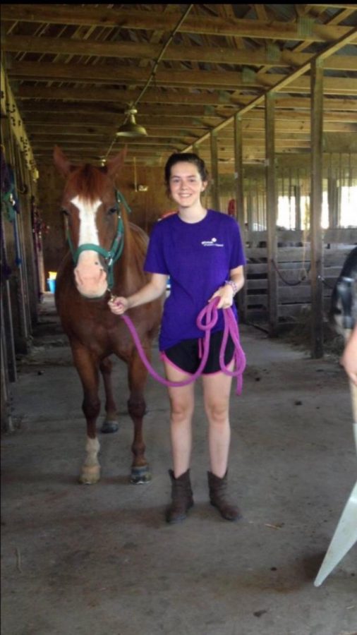Sophomore Addy Bradbury poses with her horse in the stables. She started riding horses when she was in first grade. 