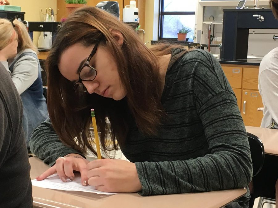 Junior Megan Ohst fills out a worksheet in her Chemistry class.