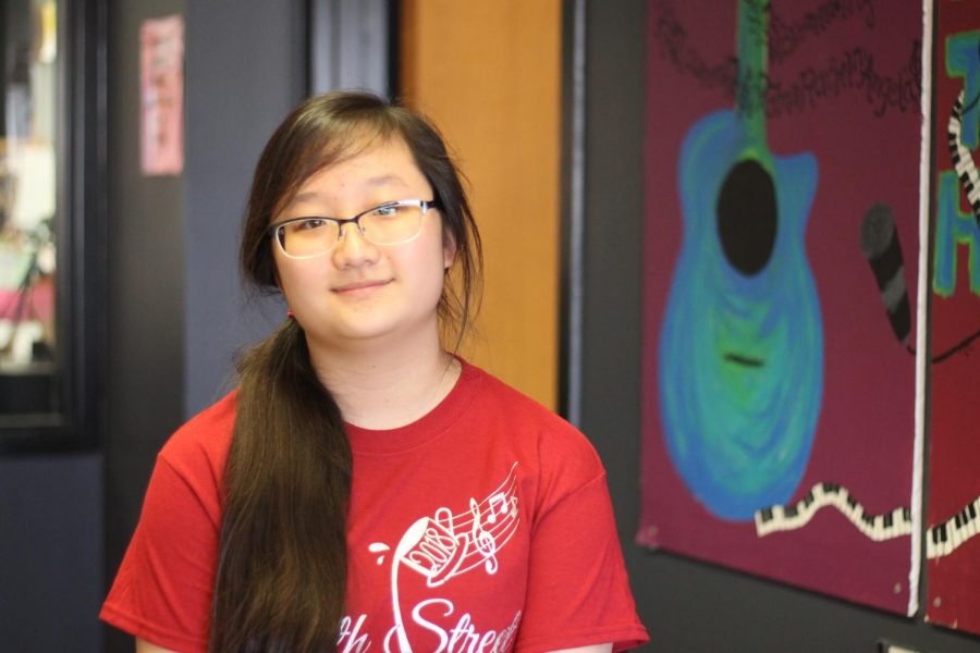 Sophomore Jena Pae poses in the Learning Commons as she wears a shirt with the winning logo she
designed for Coffeehouse. Pae entered the Coffeehouse contest with a drawing that took her over four
hours. She studied different fonts, chose her favorite and then practiced that style.
