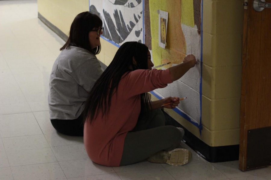 Senior Alex Rowe and junior Karen Pete work on their mural in the art hallway. They meet after school once a week. The third member of the group, Eve Abuazza said, “My favorite part about art club is that it’s just us three and over a semester we became friends and found common interests and wanted to hang out more.”