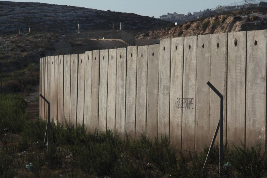 A section of the concrete Israeli West Bank barrier wall, with the world Palestine written on it, viewed from West Bank, Palestine. 