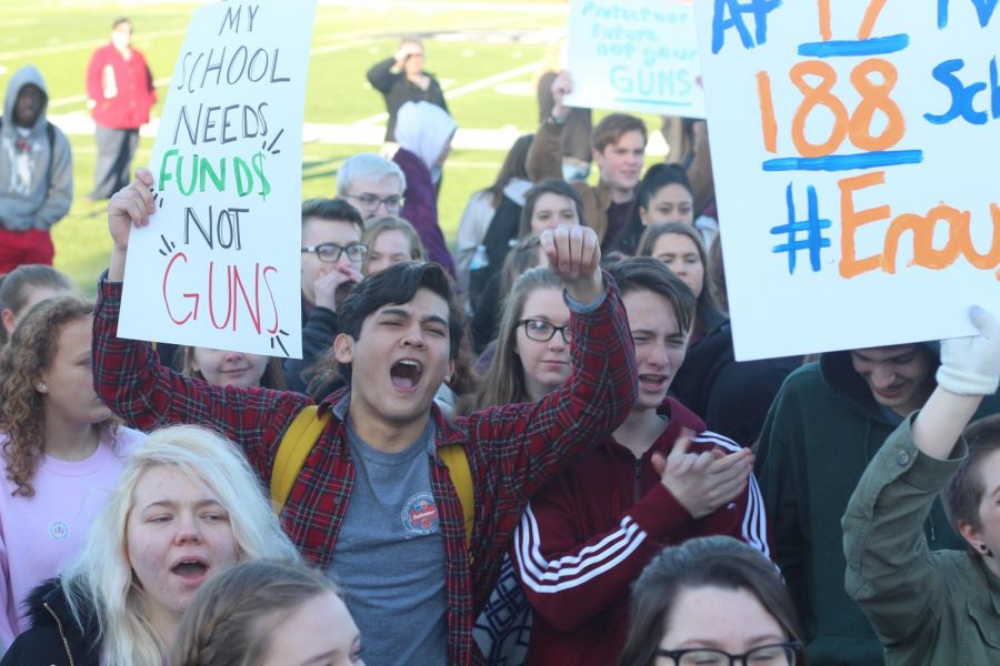 Junior Tom Condren cheers during a speech at the March 14 walkout. Students left their homerooms and met on the football
field.