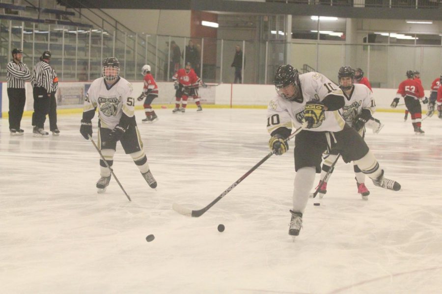 Senior Kurt Springli (#10) takes a shot on goal with fellow senior Jacob Casey watching in the background in warmups ahead of FHNs varsity hockey game vs. FZS on 11/10. 