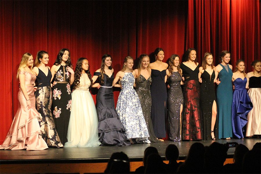 Juniors and seniors wear dresses from Davids Bridal in the 2018 Prom Fashion Show, held on Feb. 28. Different stores were included in the show by the dresses and tuxedos the models wore. The stores were Savvi, Davids Bridal and Camille La Vie.