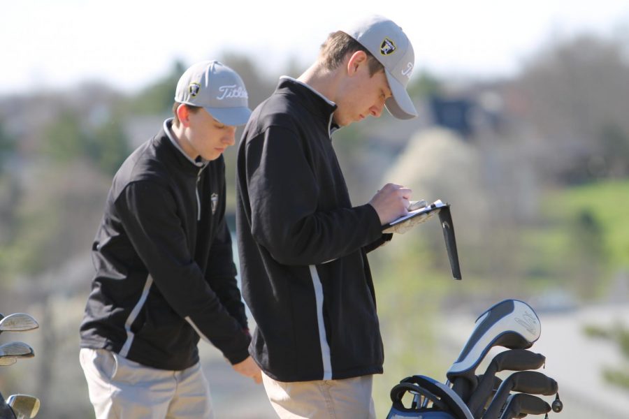 FHN players write down their scores during the round of golf.