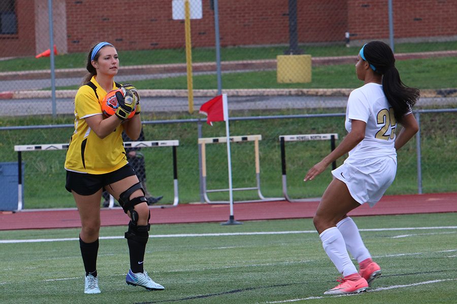 Senior goalkeeper Caty Arnold collects the ball with junior Karen Pete watching vs. Marquette on 5/3. 
