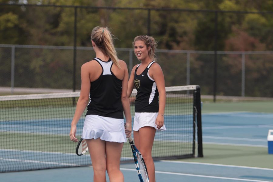 Senior Maggie Majesky talks with doubles teammate during a match against Howell on 9-21.