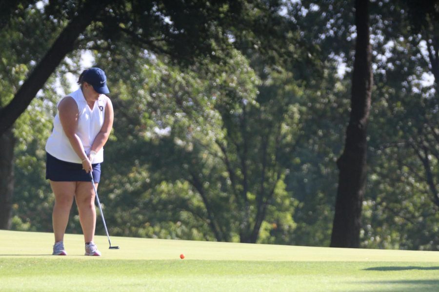 Senior Sarah LaLonde putts the ball into the hole.