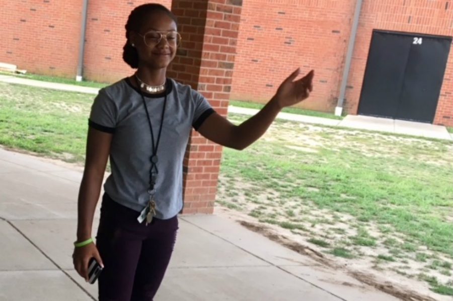 Senior Essence Green waves and greets students as they enter school for Fun Friday on Aug. 31.