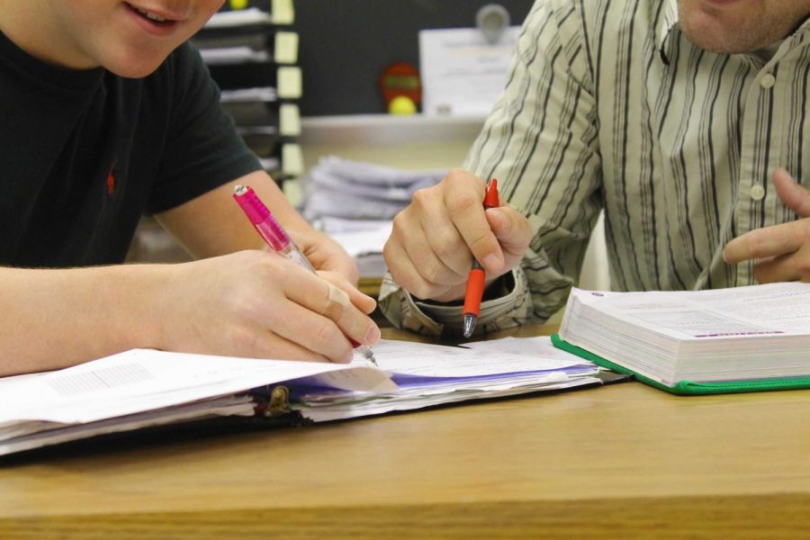 A teacher helps a student study for finals.