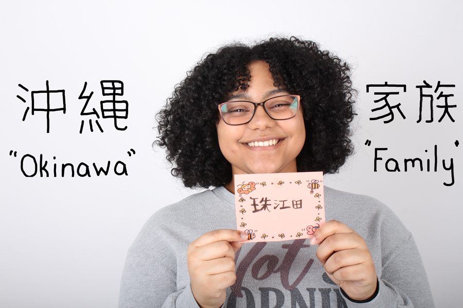 Senior+Jada+Jones+poses+with+a+card+that+has+her+name+spelled+in+Japanese.+Jones+encountered+some+difficulties+in+school+due+to+the+difference+of+language+and+spelling.+The+letter+%E2%80%9CJ%E2%80%9D+in+Japanese+has+a+negative+connotation%2C+so+she+had+to+spell+her+name+with+a+%E2%80%9CG.%E2%80%9D