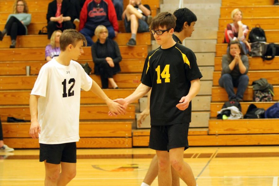 Junior Louis Primeau and Sophomore Peter Moxeley high five after gaining a point for the team. 