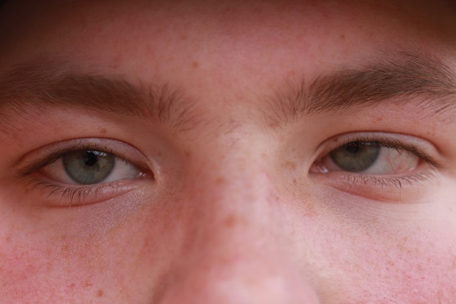 Looking at the camera, sophomore Austin Barker shows his blind eye. Barker was diagnosed with cancer in his left eye, and that lead him to be blind in
his left eye. Barker luckily lived, and the only thing his left eye does is turn different colors in different lightings.