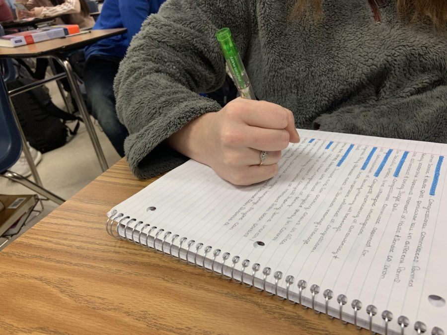 A student writes in her notebook. (Photo by Ashlynn Perez)