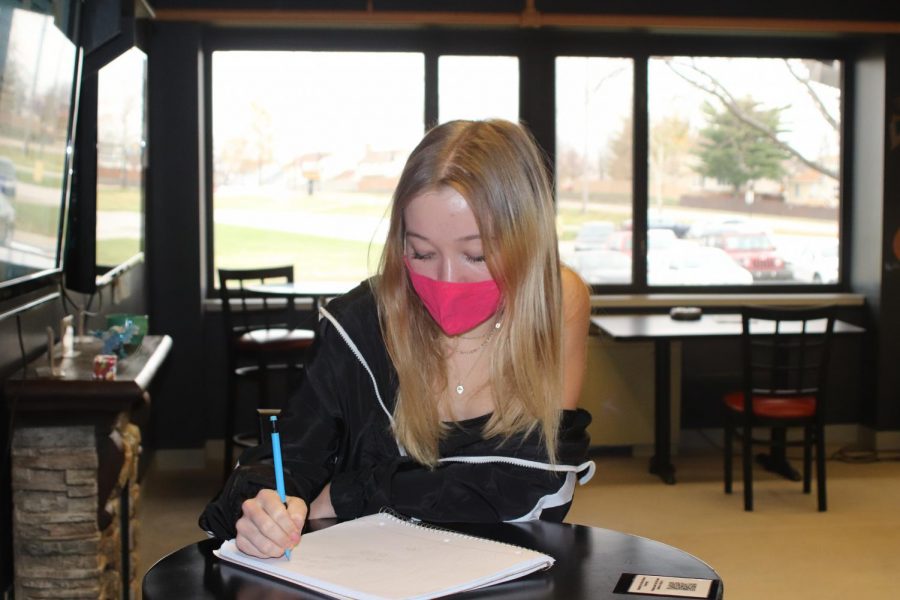 Junior Ellie Miller wears a mask while working in the Learning Commons. Mask-wearing is an important part of ensuring that the new quarantine policy is safe and effective.