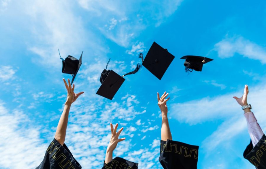 Four graduation caps are thrown into the air. Graduation will take place June 5. (Photo from Shutterstock)