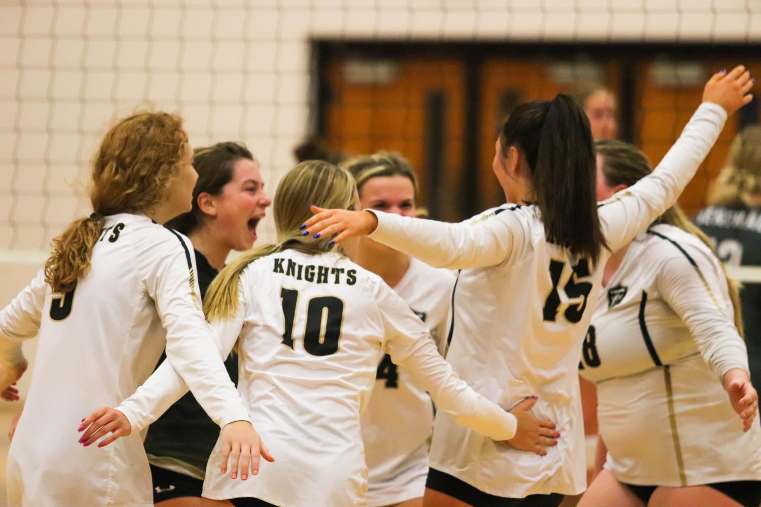 The team heads to hug in celebration during their volleyball game