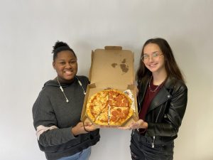 Juniors Morgan Chairs and Chloe Ellison hold a pizza.