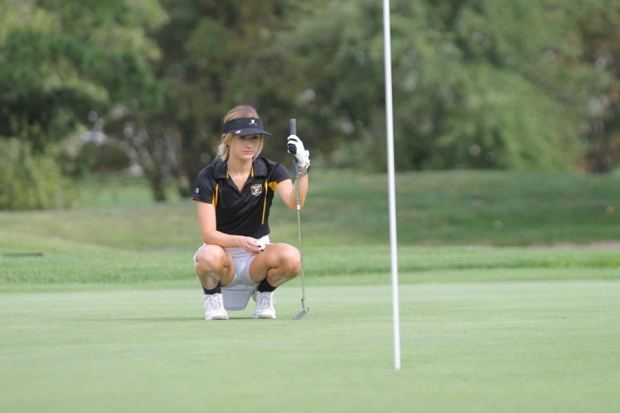 Junior Chloe Perkins prepared for her next put on the golf green.
