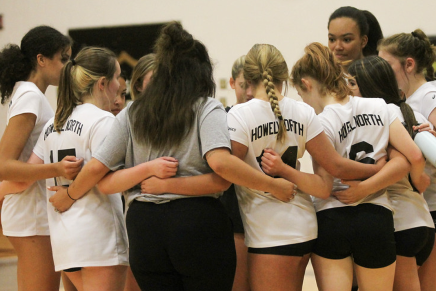 The jv volleyball team huddles together during a game on Sept. 28.