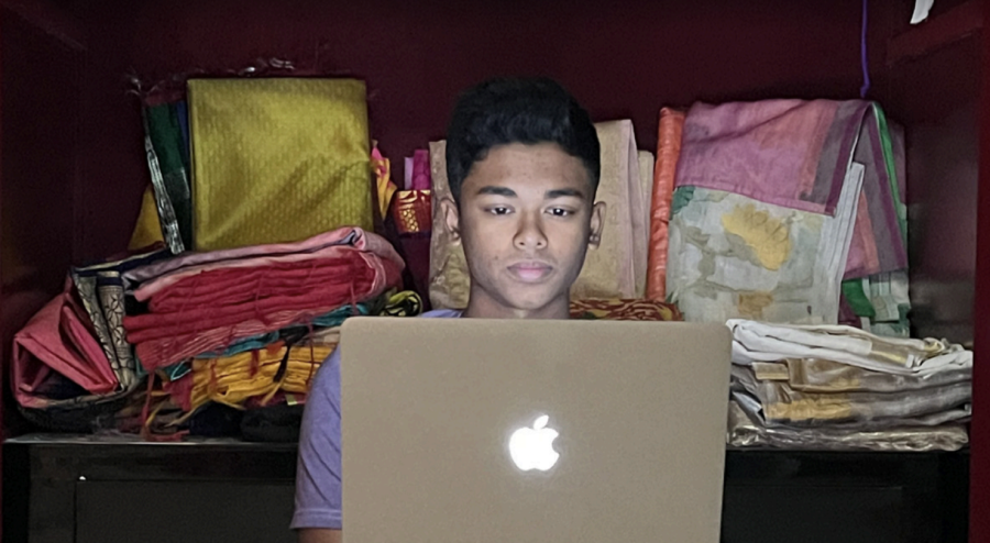 Working on his online businesses Nov. 14, senior Pavan Kolluru works on his website in front of a wardrobe of sarees. Kolluru came up with Ethnic Touch when he saw his mom struggling to buy Indian garments online. 