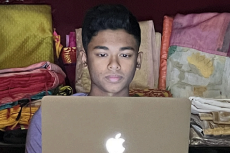 Working on his online businesses Nov. 14, senior Pavan Kolluru works on his website in front of a wardrobe of sarees. Kolluru came up with Ethnic Touch when he saw his mom struggling to buy Indian garments online. 