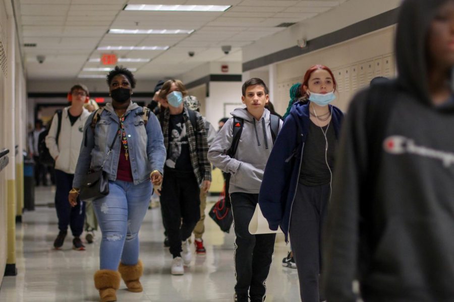 Students walk to class on Nov. 17, some with masks and without. The mask policy in the building changed to be optional, as compared to last year where it was required.