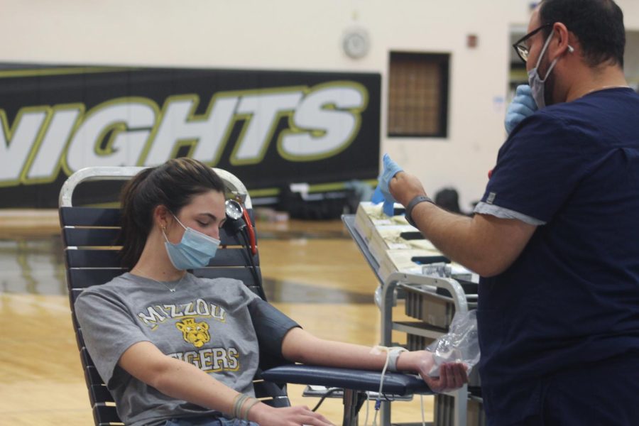 Junior Maggie Koester gives blood at the HOSA blood drive in the big gym on April 4th