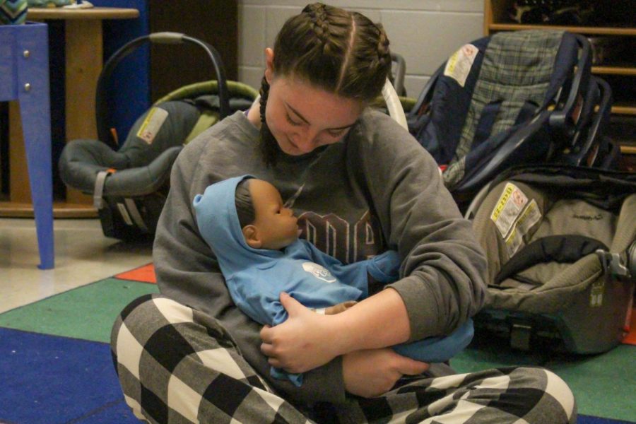 Sophomore Ellie Barnum cradles a baby in the nursery on Nov 17. She supports the head, while making sure it feels comfortable. Students who take the Child Development class are taught that when it comes to picking up babies it’s important to be careful, because of how delicate they are. “Having a basic foundation of what a healthy pregnancy looks like and how to have positive interactions with children is something that benefits every single person on this planet” Mrs.White said.