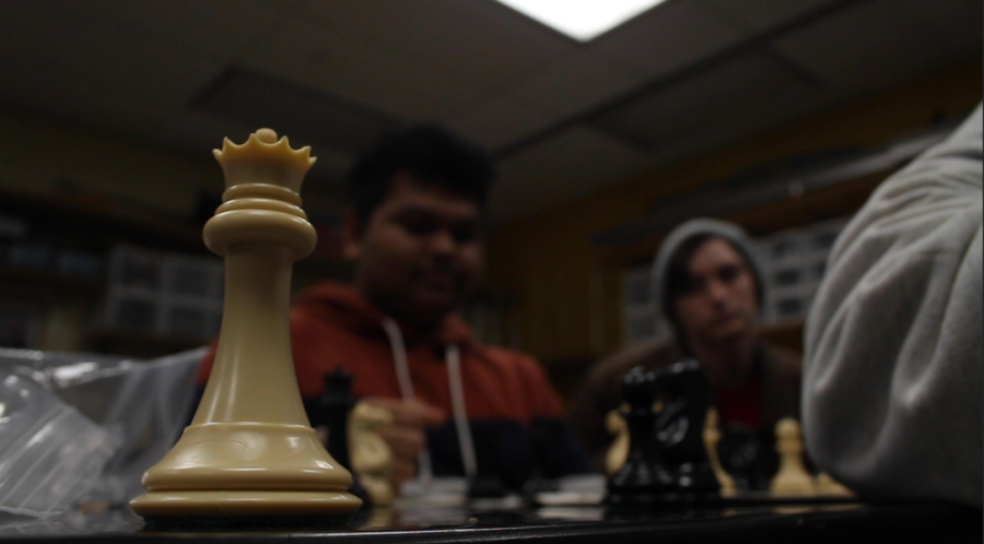 Seniors Robert Otte and Ved Thakor watch as senior Joeseph Cuneo teaches them checkmate drills during the chess club meeting on Dec. 1.  