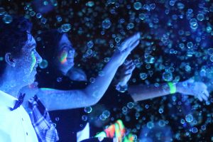 Two students are fascinated by the glow and the dark bubbles at the 2017 Snowcoming dance. 
