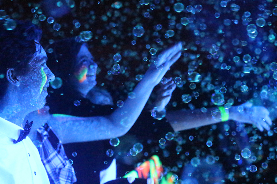 Two+students+are+fascinated+by+the+glow+and+the+dark+bubbles+at+the+2017+Snowcoming+dance.+%0A