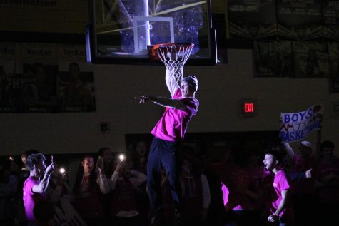 Senior Ryan Murdock dunks basketball durinrg pep assembly while running out with the FHN boys basketball team. Varisty and Junior Varsity sports runs out with their teammates to showcase their sport in the 2022 snowcoming pep assembly