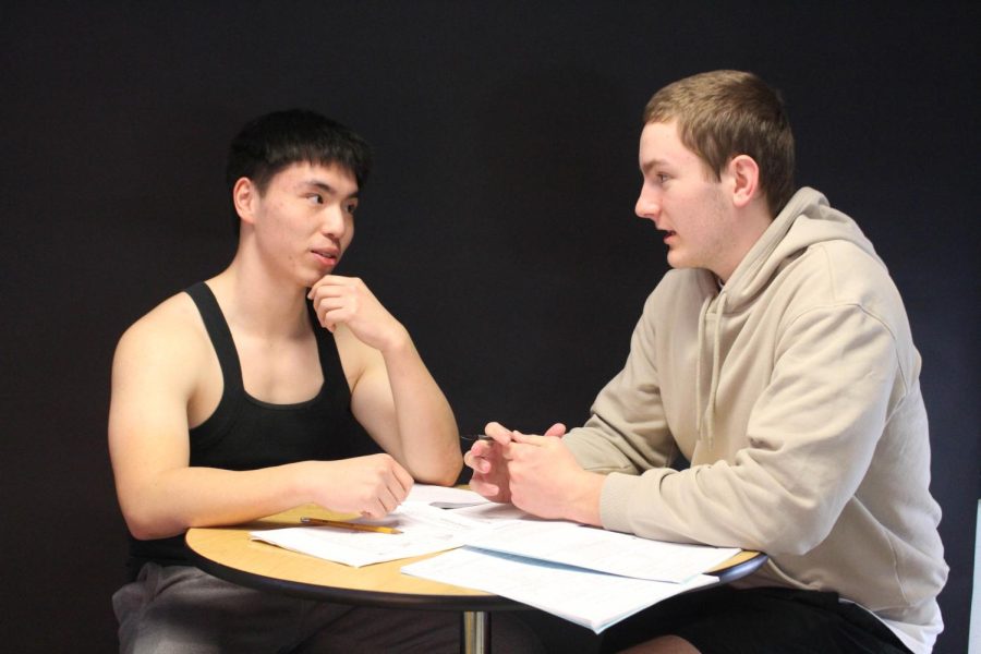 Seniors Pacino Lin and Jadon Gauerke sit at a table and discuss high school life. 