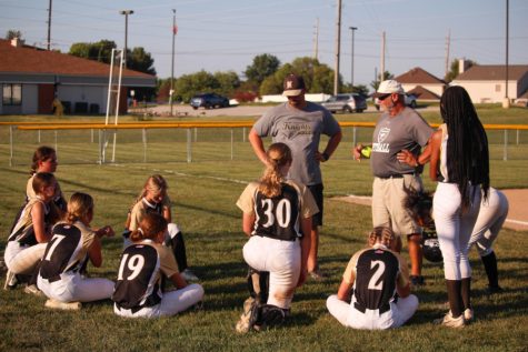 Steve Moorman leads the JV softball team in a group huddle after their game against Troy on Sept. 20th.
