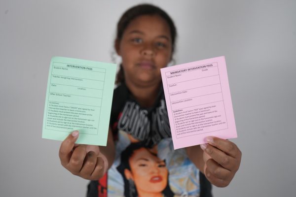 A student holds up a green pass (left) and a red pass (right). 